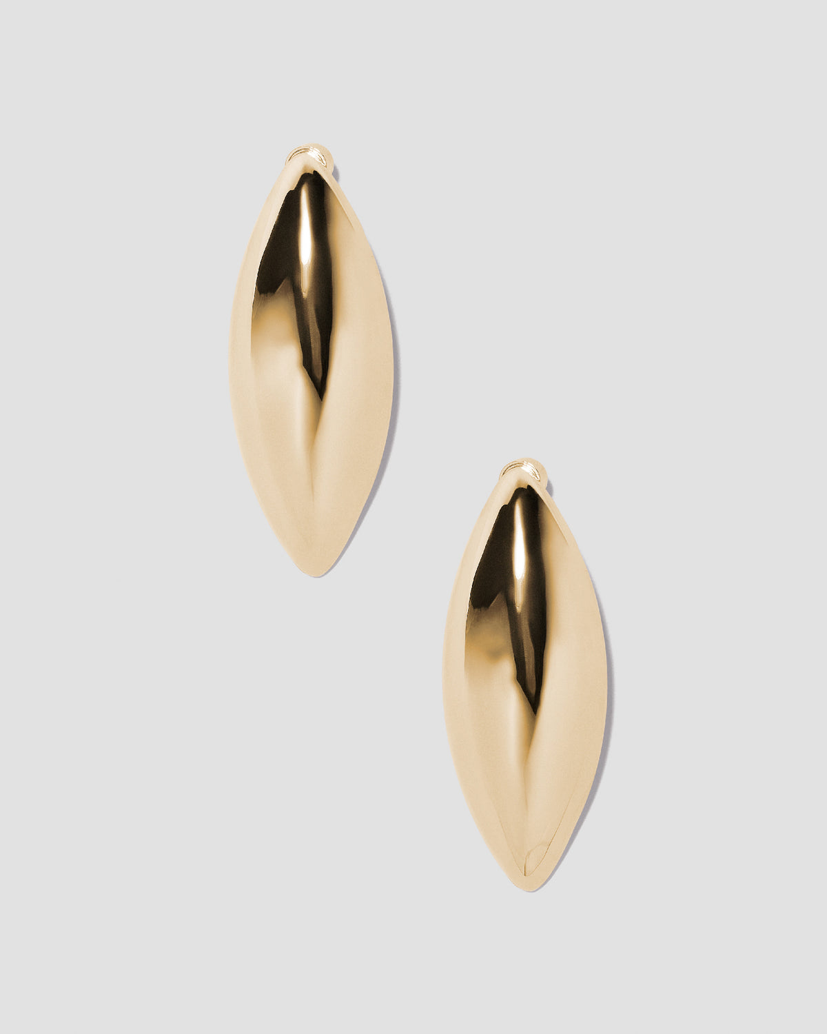 Puffy Dagger earrings on grey background.
