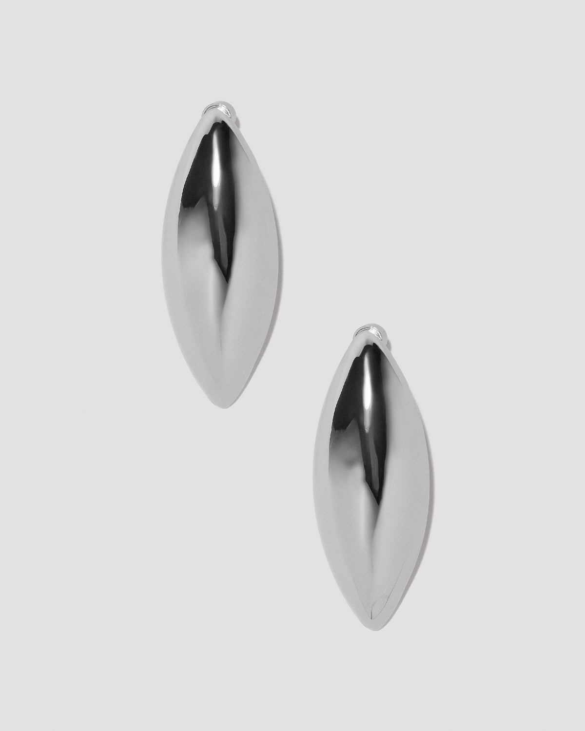 Puffy Dagger earrings on grey background.