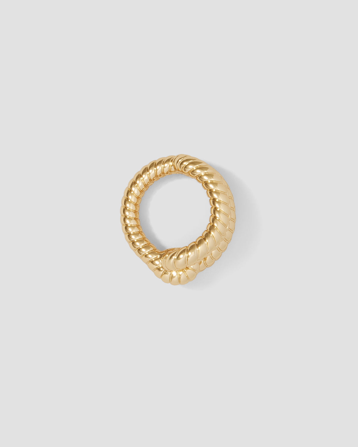 Gold ring with a textured design on a light gray background