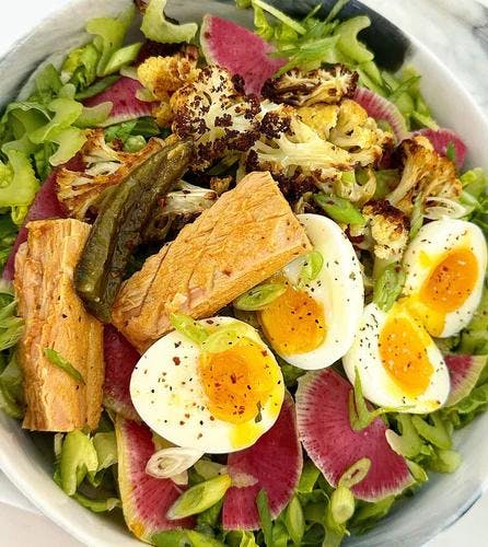 Salad bowl packed with greens, roasted cauliflower, watermelon radish, celery, green onion, 2 jammy eggs, and 2 tuna fillets. Dressed with JF Mustard Vinaigrette and JF Spicy Salt. 
