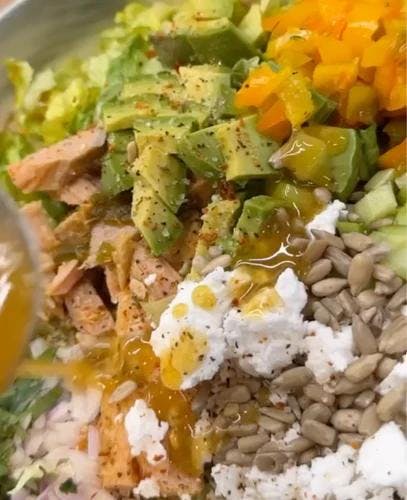 Up close image of salad with chopped avocado, raw sunflower seeds, vegan feta and flaked tuna. Dressed with JF Mustard Vinaigrette. 