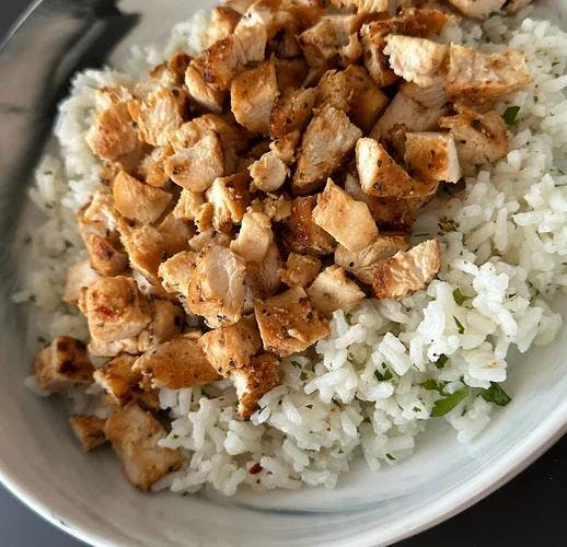 Organic cilantro lime rice plated with sliced grilled chicken 