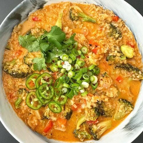 Bowl of Vegetarian Curry packed with cauliflower rice, broccoli, zucchini, red pepper, and carrots. 
