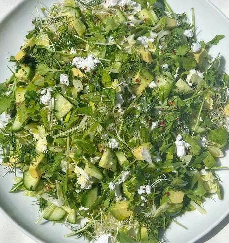 Romaine and arugula salad topped with chopped cilantro, cucumber, vegan feta, and avocado. 