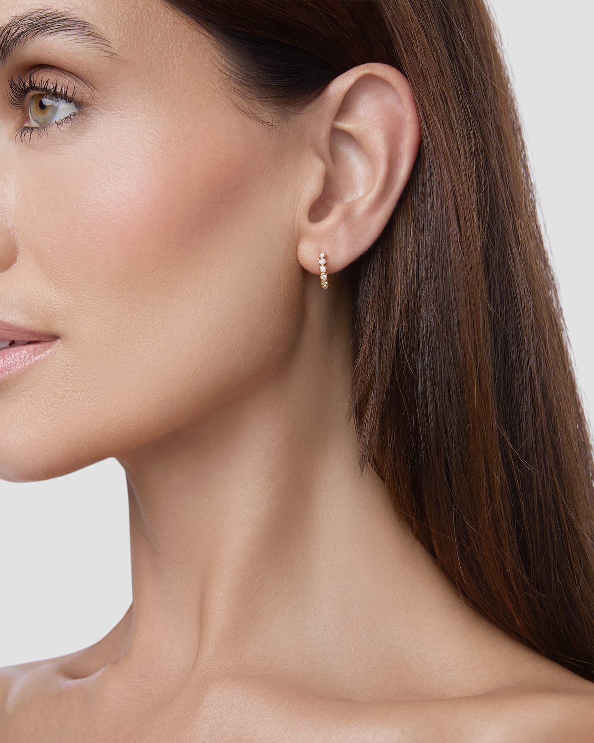 Essential Round Diamond Bezel Huggie gold earring - close-up detail | diamond huggie earrings
