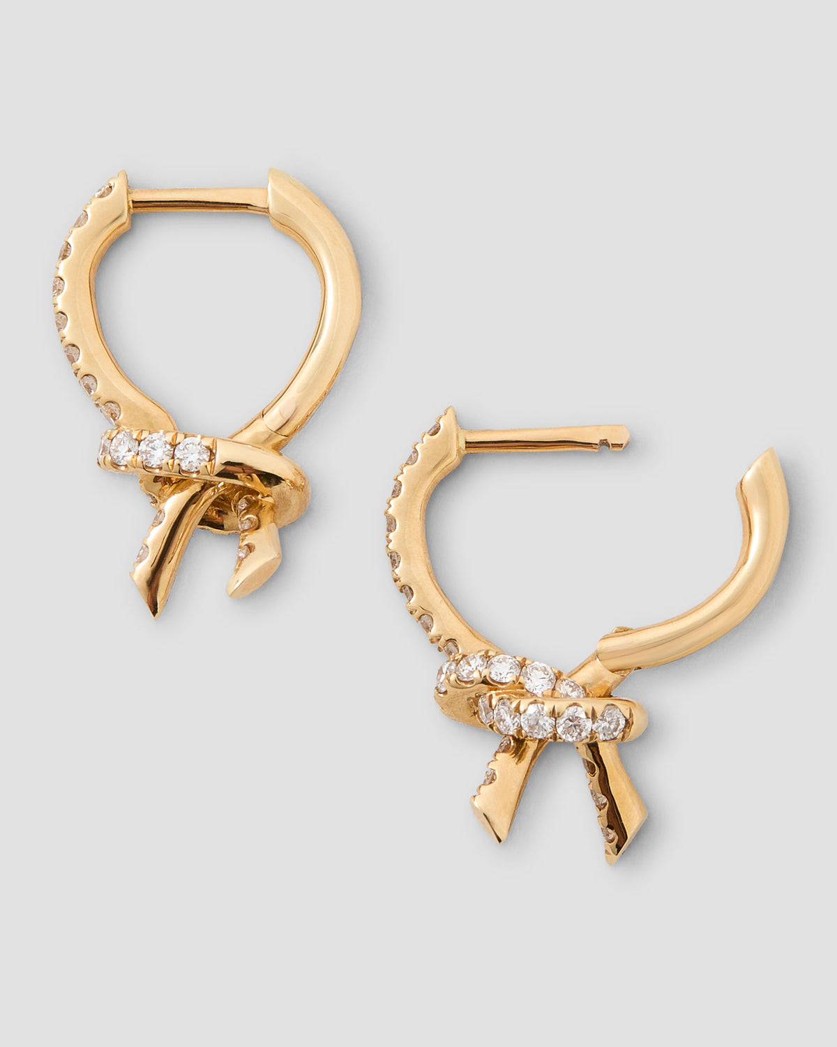 Knot Huggie with Pavé White Diamonds gold earring - styled on model | diamond huggie earrings
