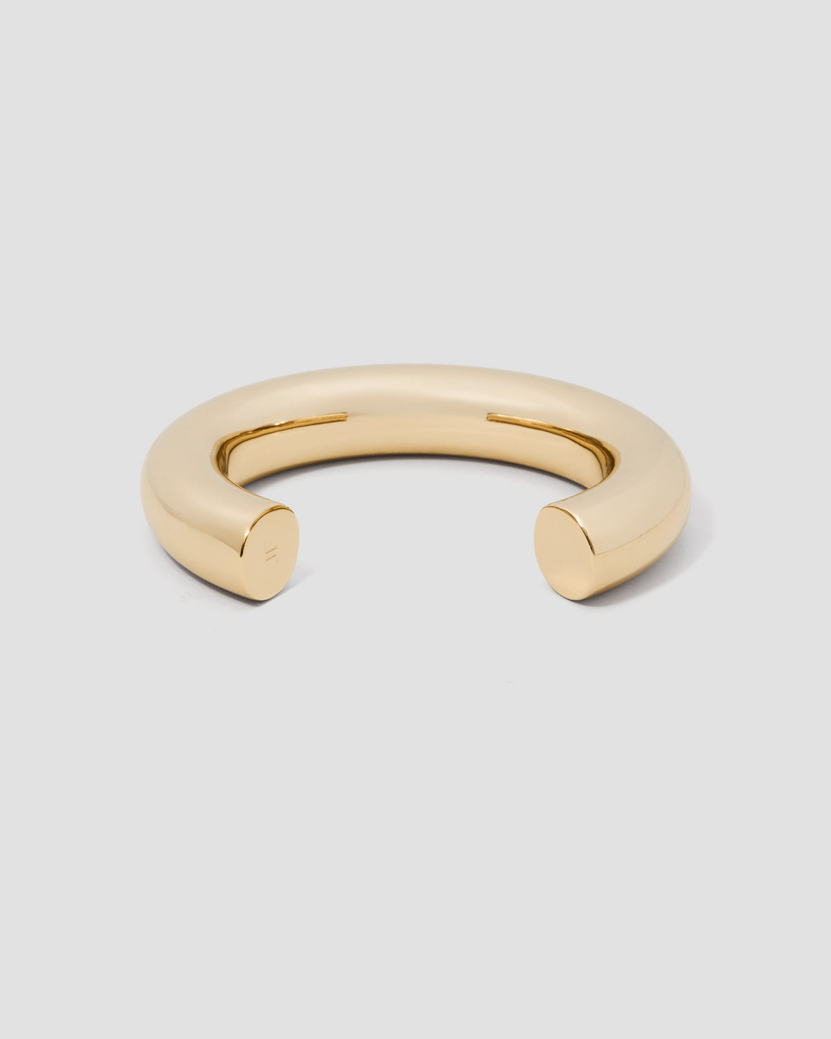 Gold bracelet on a light gray background
